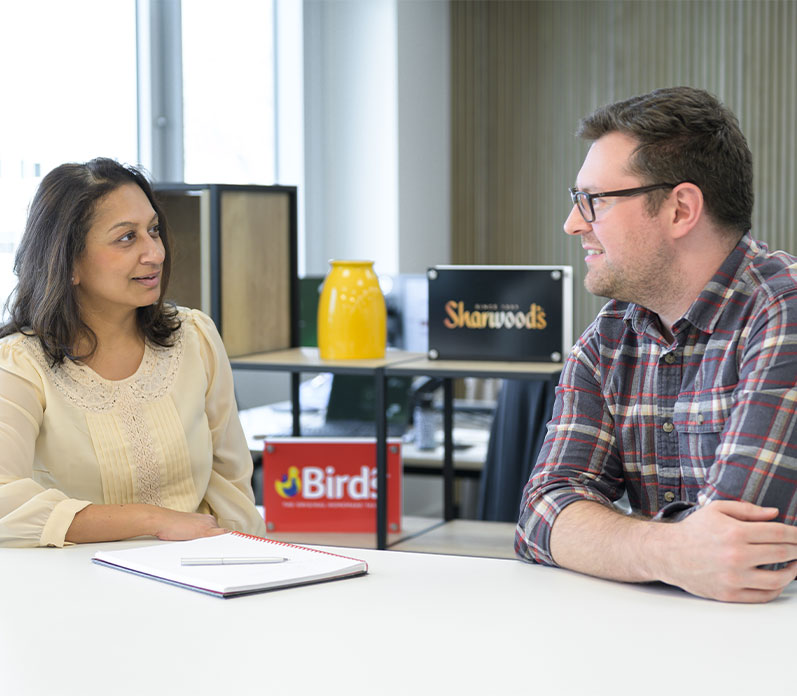 Two colleagues at desk with brands displayed